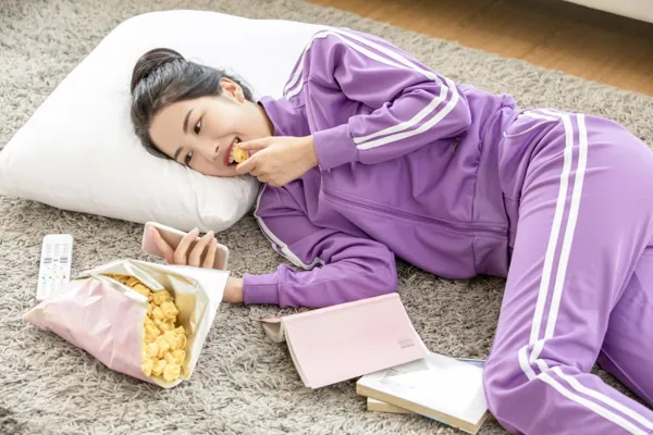 Person watching a device and snacking