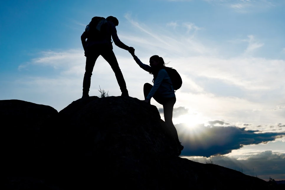 Hikers helping one another